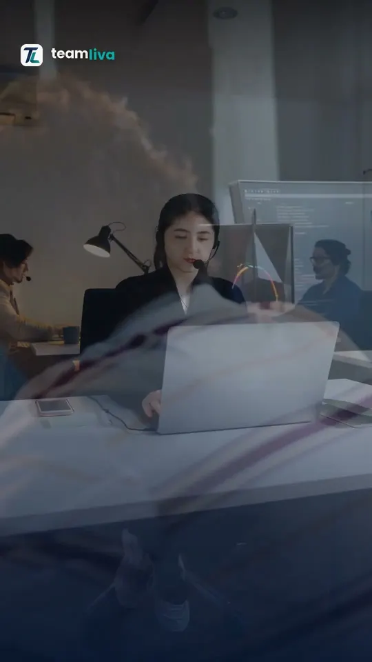 Teamliva video still: a support specialist with a headset working at a laptop in a busy office